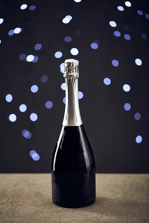 one bottle of sparkling wine with blurred christmas lights