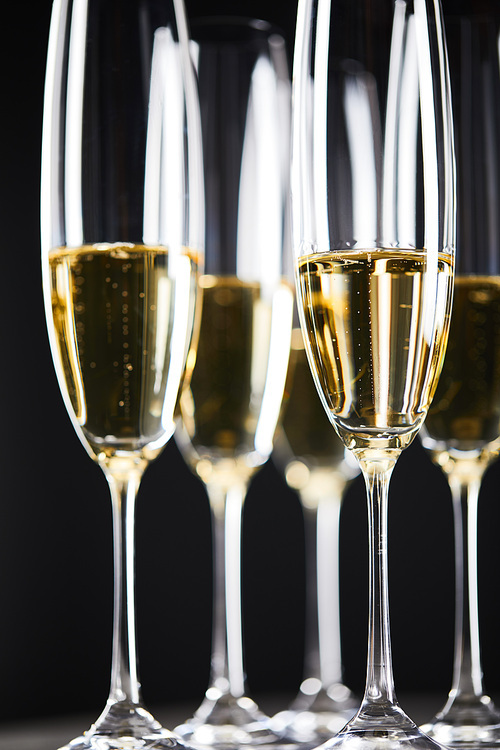 close up of sparkling wine in glasses on black