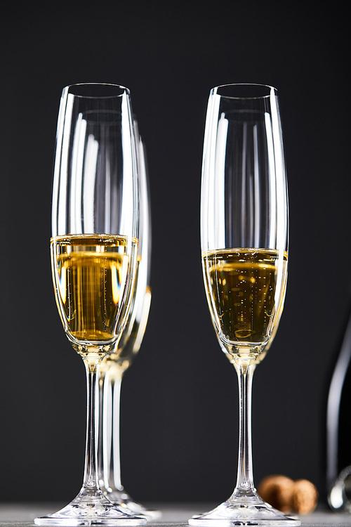 close up of champagne in glasses for celebrating christmas eve on black