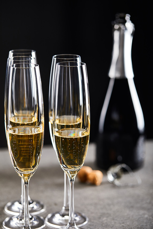 glasses and bottle of sparkling wine for celebrating christmas on black