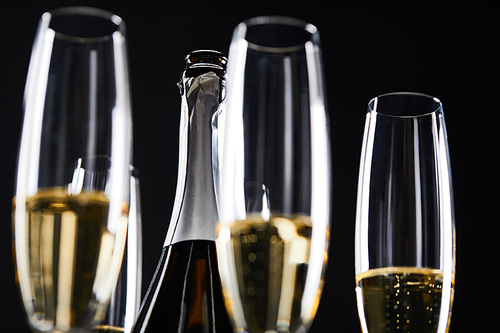 glasses and bottle of sparkling wine for celebrating christmas, isolated on black