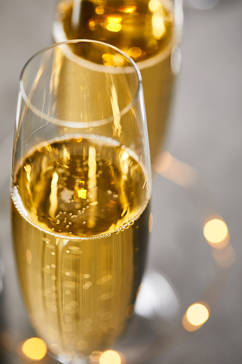 close up of glasses of champagne with blurred yellow christmas lights