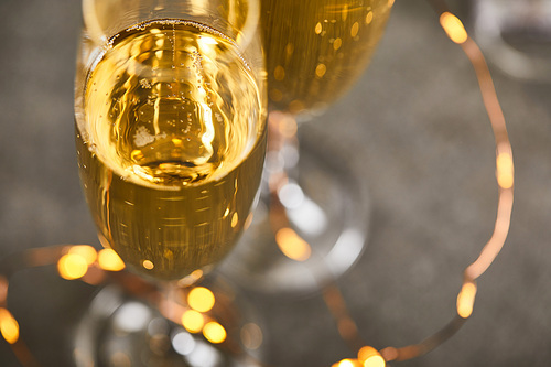 close up of glasses of sparkling wine with blurred yellow christmas lights