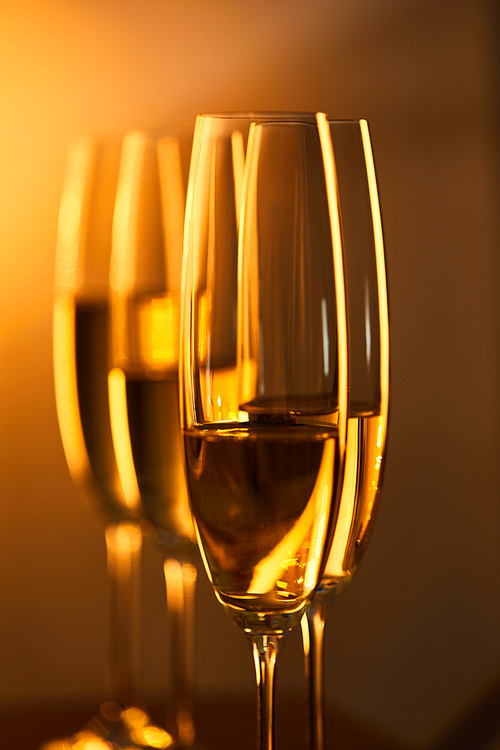 close up of glasses of champagne with blurred yellow christmas lights