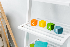 close up view of multicolored cubes with kids lettering on shelf
