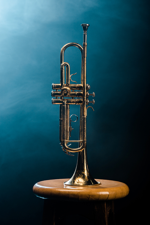 studio shot of trumpet on chair with dramatic lighting background