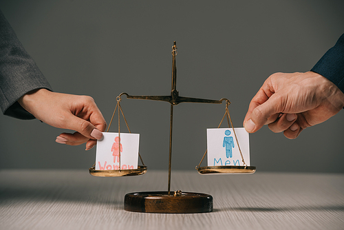 cropped view of businesspeople with male and female signs on scales of justice, gender equality concept