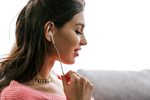 beautiful smiling indian woman listening music with earphones