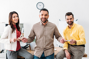 advisor standing and taking money from man and woman in office