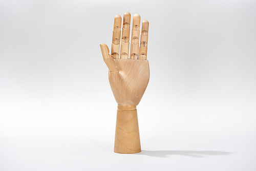 Hand of wooden doll on gray background