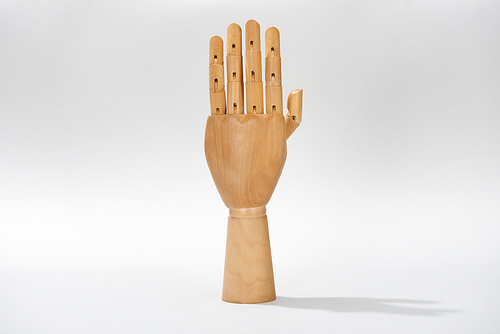 Wooden hand with shadow on grey background