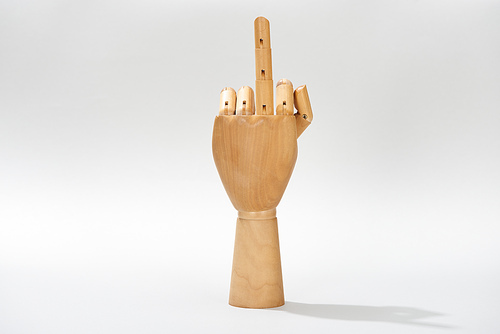 Wooden hand with middle finger gesture on grey background