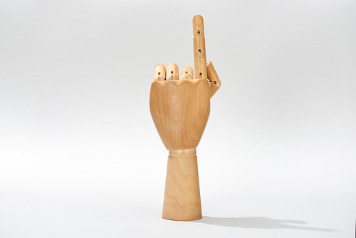Wooden hand of puppet pointing with finger on grey background