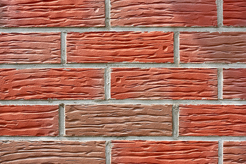 close-up view of red weathered brick wall, textured background