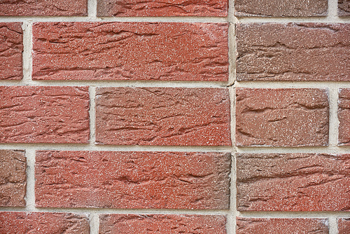 full frame view of red weathered brick wall, textured background