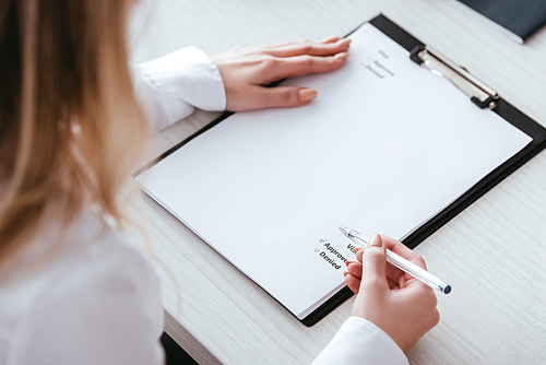 selective focus of woman putting check sign on document with lettering