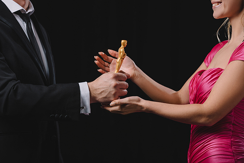 partial view of man giving oscar award to woman isolated on black