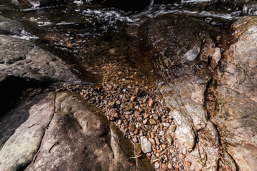 sunlight on small rocks near flowing water