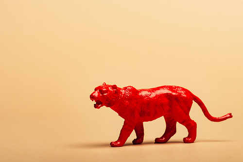 Red toy tiger on yellow background, animal welfare concept