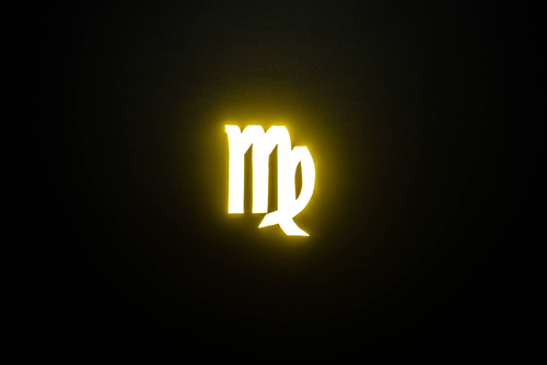 yellow illuminated Virgo zodiac sign on black background