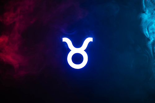 blue illuminated Taurus zodiac sign with colorful smoke on background