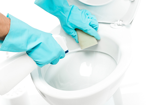 cropped view of man in rubber gloves cleaning toilet bowl with detergent and sponge on white