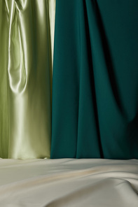 close up view of emerald, light green and white soft and wavy silk fabric