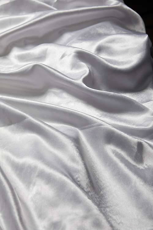 close up view of white soft and crumpled silk textured cloth