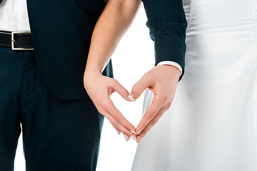 cropped view of bride and groom showing heart sign with hands isolated on white