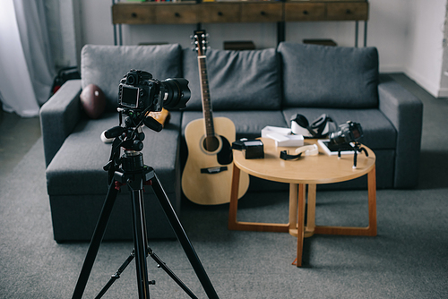 acoustic guitar and cameras with wooden table in empty room