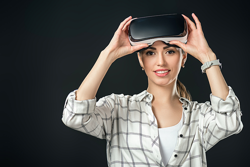 smiling woman using virtual reality headset, isolated on black