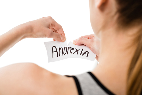 cropped shot of woman tearing paper with anorexia inscription isolated on white