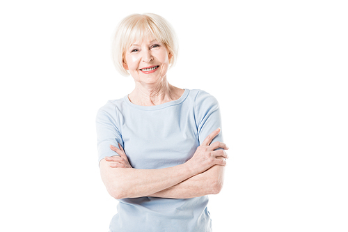 Smiling senior woman standing with crossed arms isolated on white