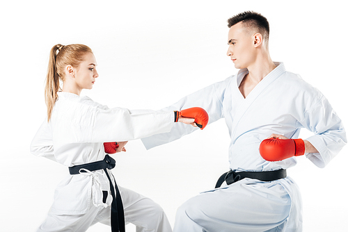 side view of karate fighters training in kimono and red gloves isolated on white