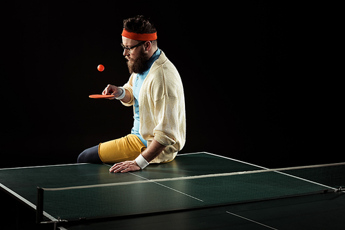 bearded tennis player practicing in tennis isolated on black