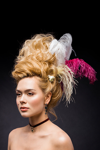 elegant and attractive woman with feathers in wig on black