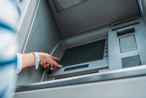 low angle view of woman pressing button on atm machine