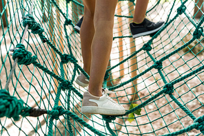 cropped view of kids standing on high rope trail