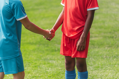 cropped view of multicultural kids shaking hands