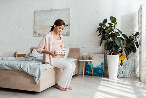 pregnant woman holding wooden blocks with word baby