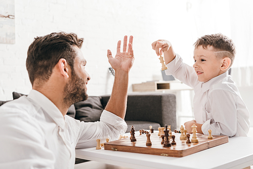 dad and son playing chess together at home