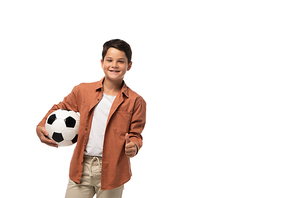 cheerful boy holding soccer ball and showing thumb up isolated on white