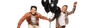 panoramic shot of two happy boys with black festive balloons isolated on white