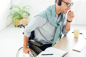 Smiling call center operator in wheelchair talking on headset