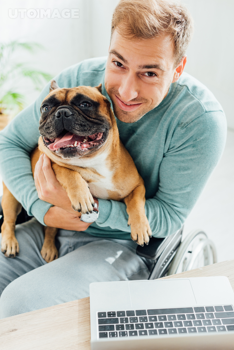 유토이미지 | Disabled man holding french bulldog and smiling at camera