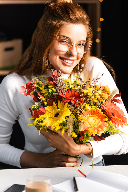 유토이미지 smiling woman with bouquet of autumn flowers in cafe