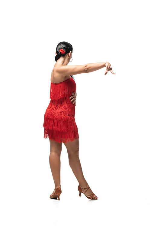 sensual dancer in stylish dress with fringe performing tango on white background
