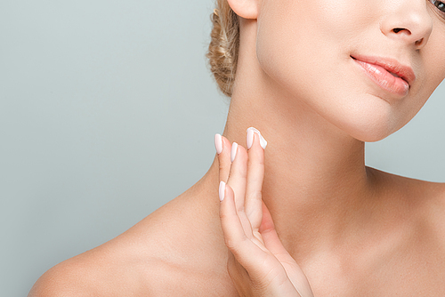 cropped view of woman applying cosmetic cream on neck isolated on grey