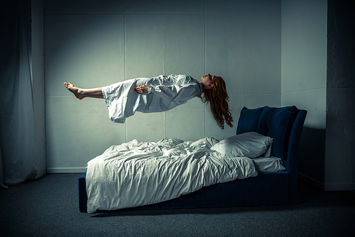 obsessed girl in nightgown sleeping and levitating over bed