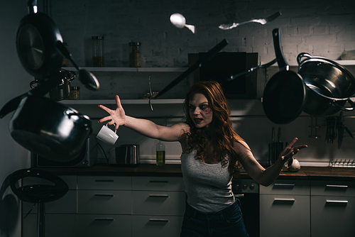 creepy demoniacal girl with levitating pots and knives in kitchen